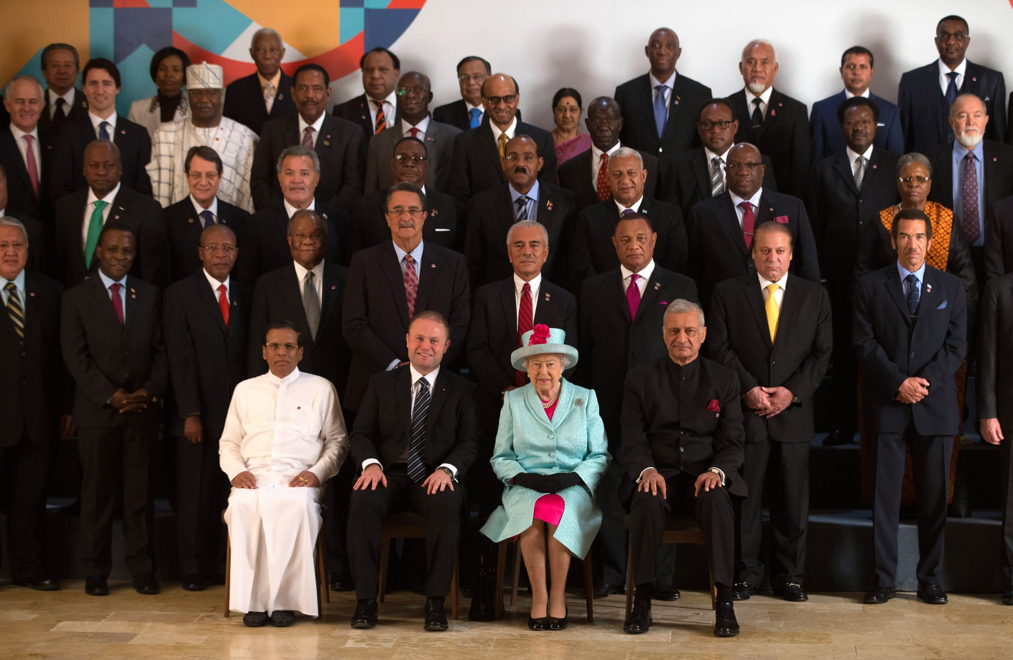 The Queen sits in the center of a group photo of Commonwealth heads of state.