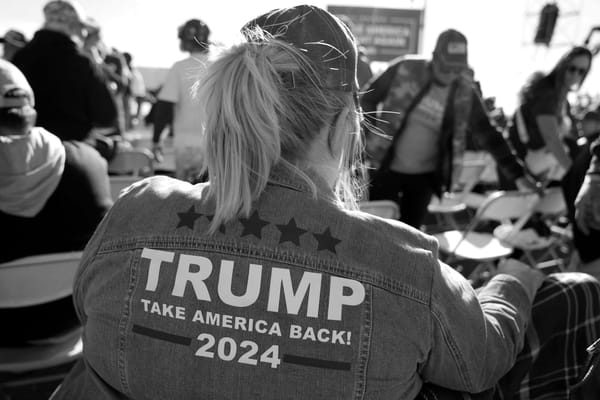 A photo of a woman, seen from behind, wearing a denim jacket with Trump 2024 on it.