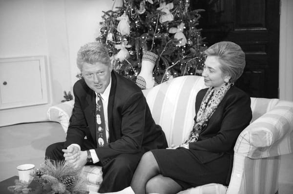 A black and white photo of Hilary and Bill Clinton relaxing in the Roosevelt Room in the White House.